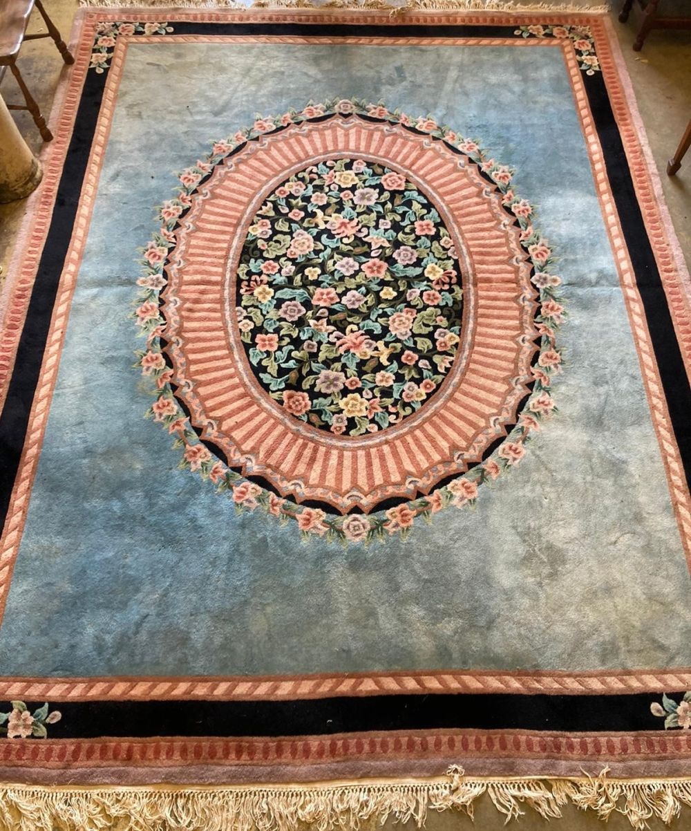 An Indian floral medallion carpet, with a sky blue field within a pink and blue border, 375 x282cm